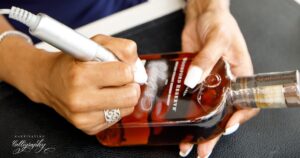 Calligrapher engraving a luxury item by hand in studio